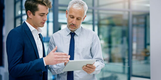 2 SAP Project Managers discussing notes on a notepad